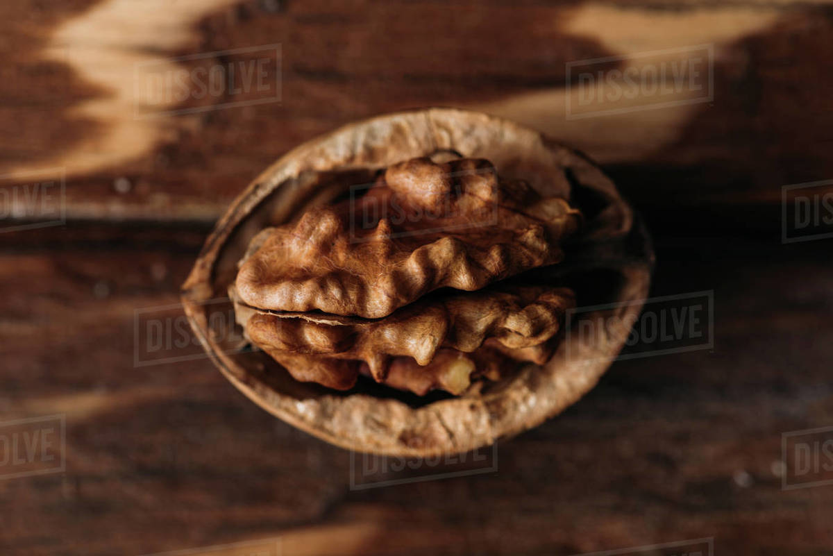 Top view of walnut in nut shell as dementia symbol on wooden table