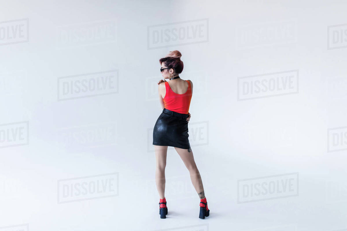 Back view of stylish girl posing for fashion shoot, isolated on 