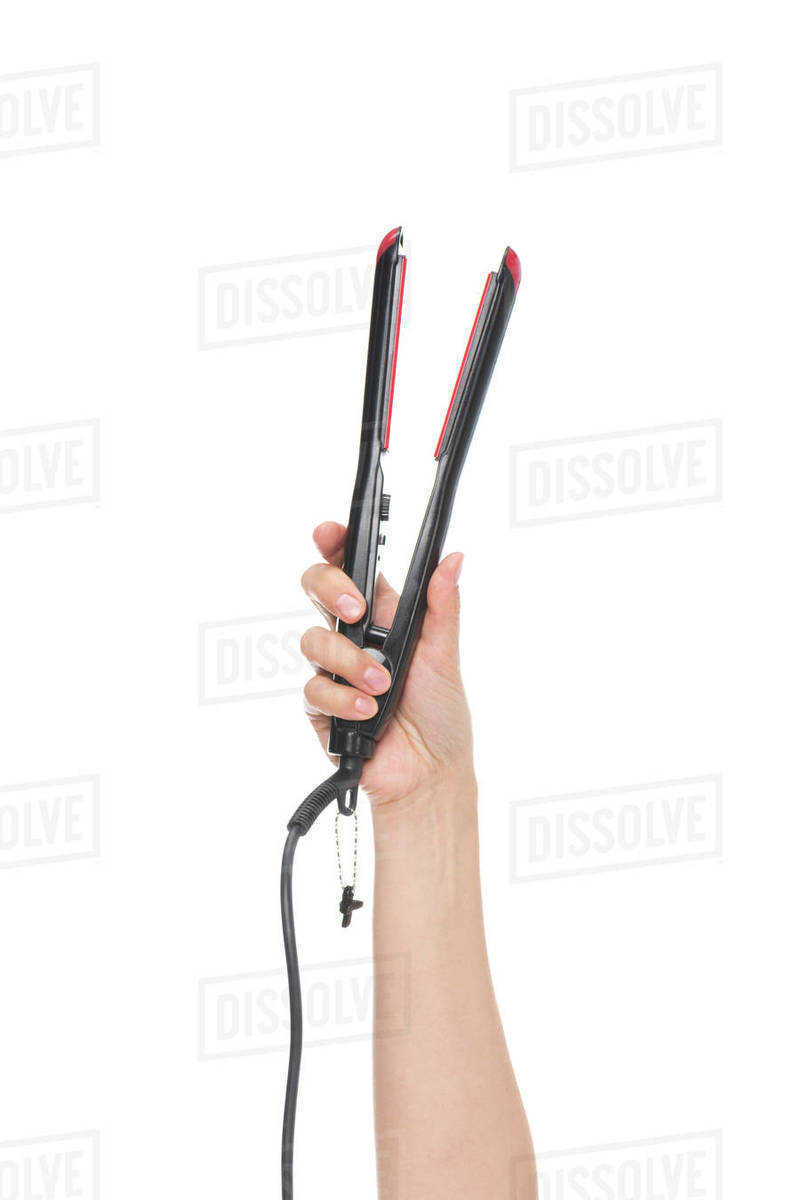 Cropped shot of female hand showing hair straightener isolated on white