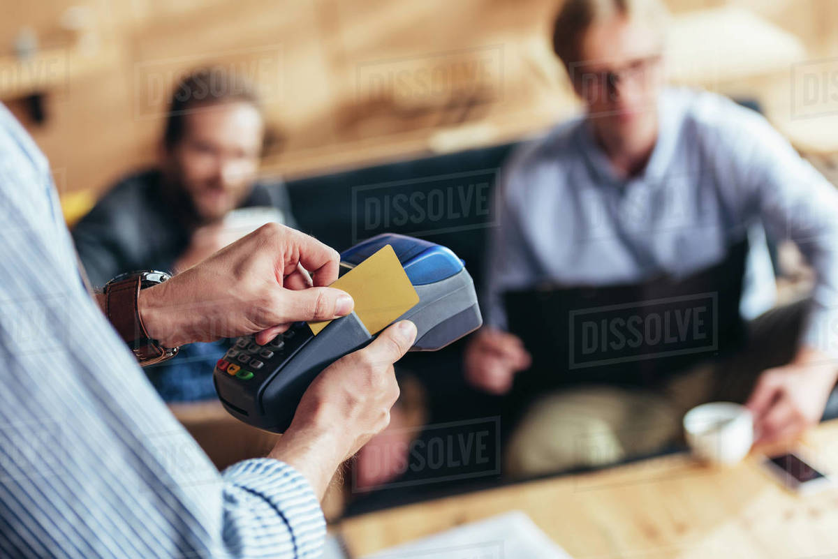 Cropped shot of waiter using payment terminal and credit card Stock