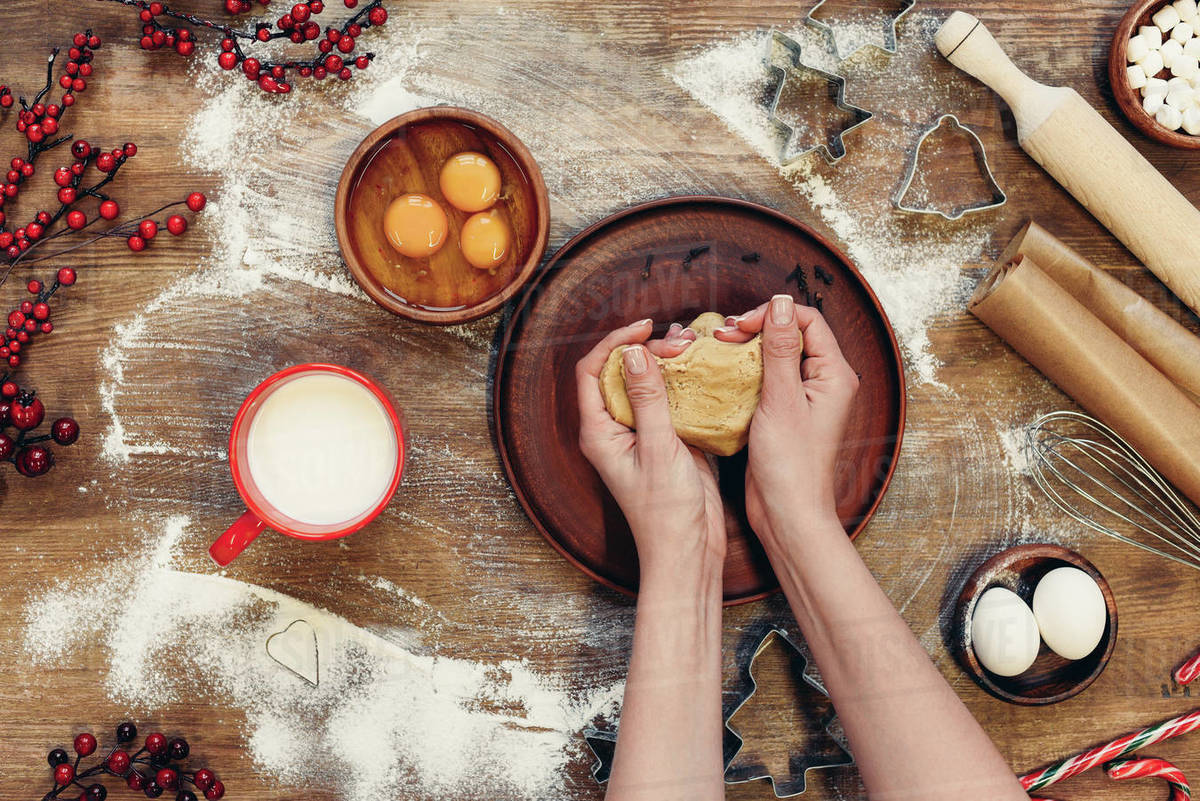 top view of hands kneading gingerbread dough for christmas cookies