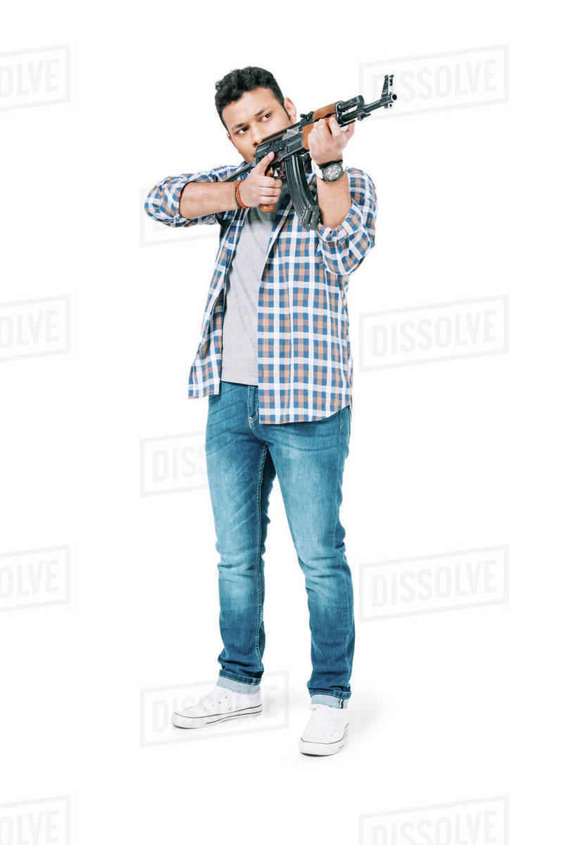 Full length view of young African American man holding rifle and ...