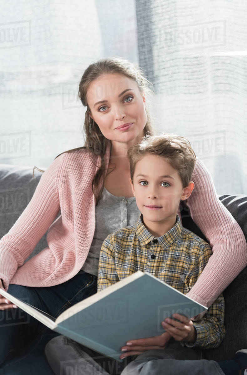 Mother and son holding a book and posing to the camera Stock Photo