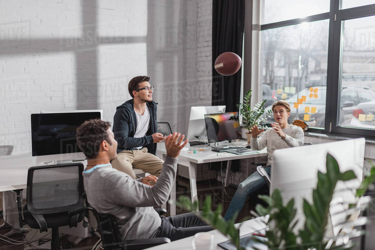 Men playing with ball in modern office - Stock Photo - Dissolve