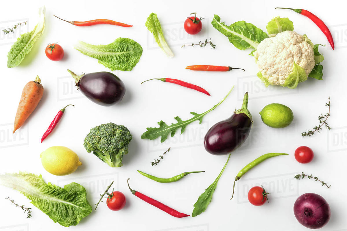 Top view of different uncooked vegetables isolated on white Stock Photo Dissolve