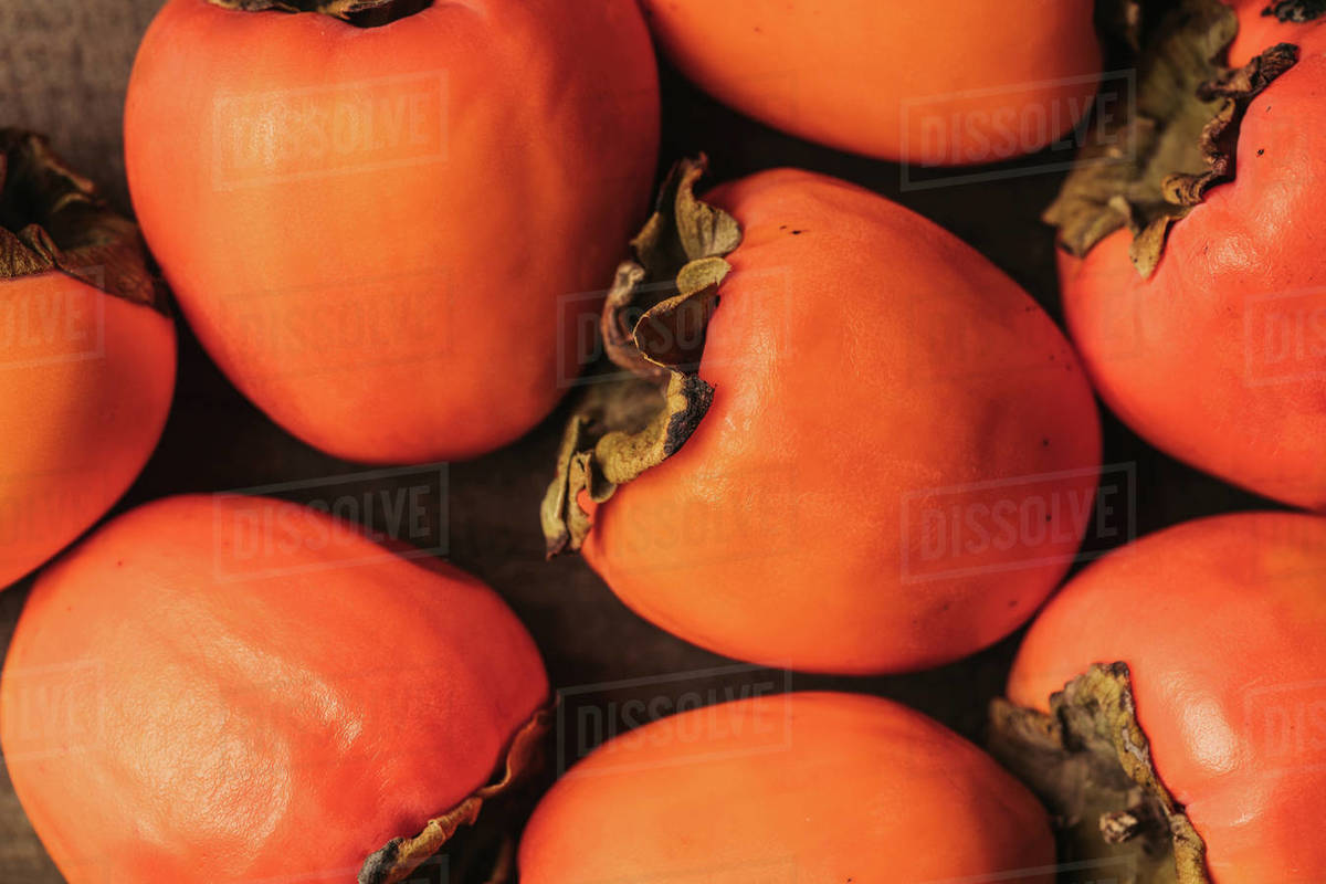 top view of ripe orange persimmons - Royalty-free Stock Photo | Dissolve