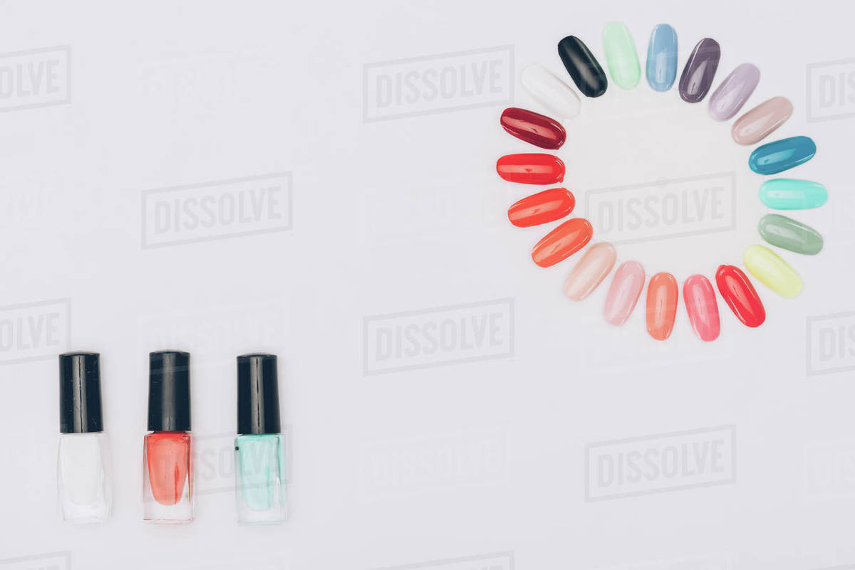 Top view of colored nail polishes and manicure palette isolated on