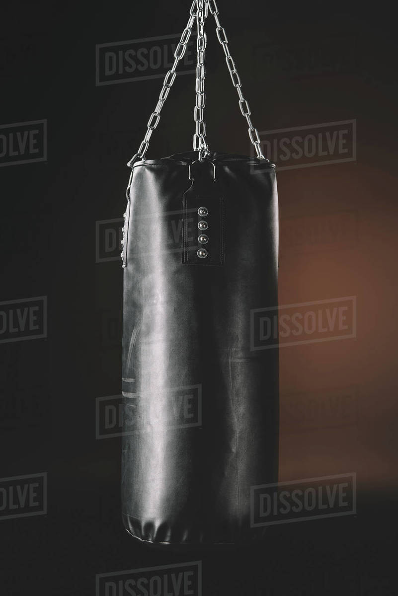 Close Up View Of Black Punching Bag Hanging In Darkness Action Punching Bag Hanging In Darkness