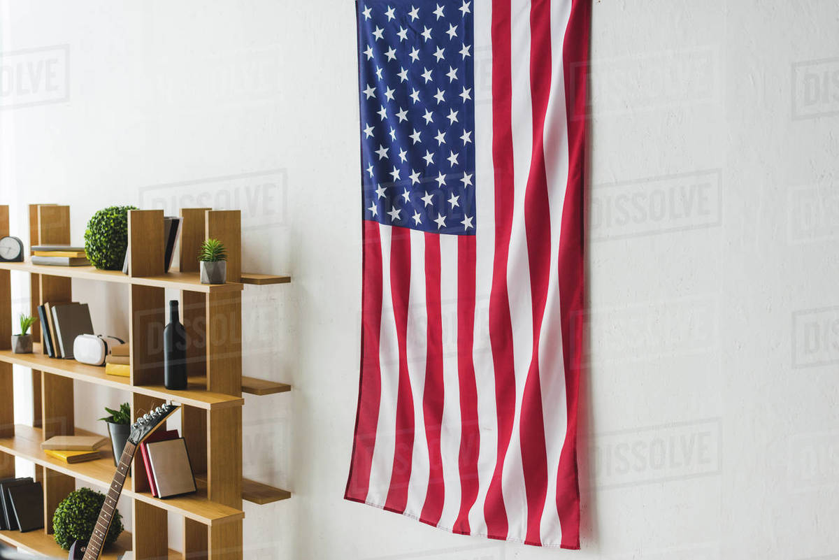 American flag hanging on wall inside living room Stock Photo Dissolve