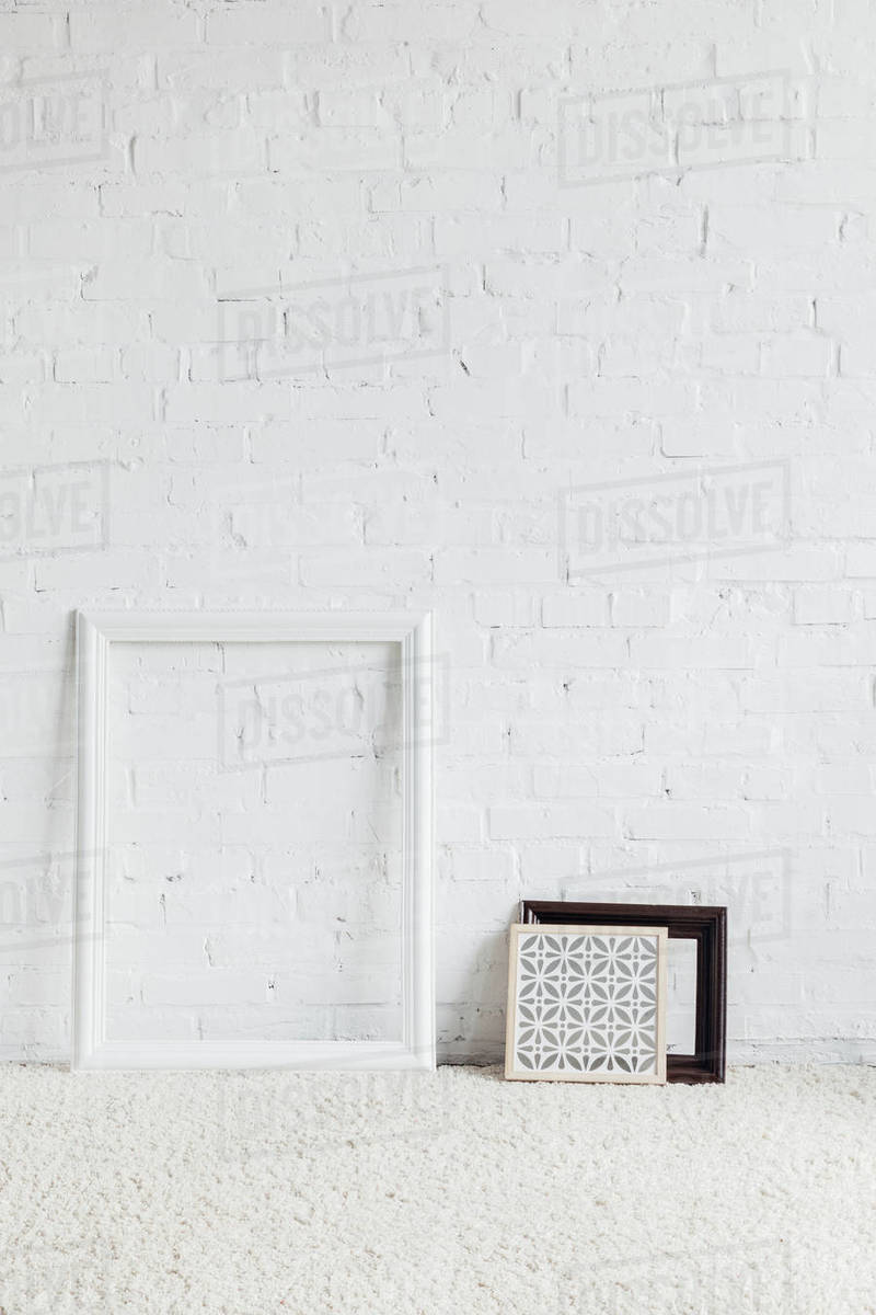 Picture frames with leaning on white brick wall, mockup concept Stock