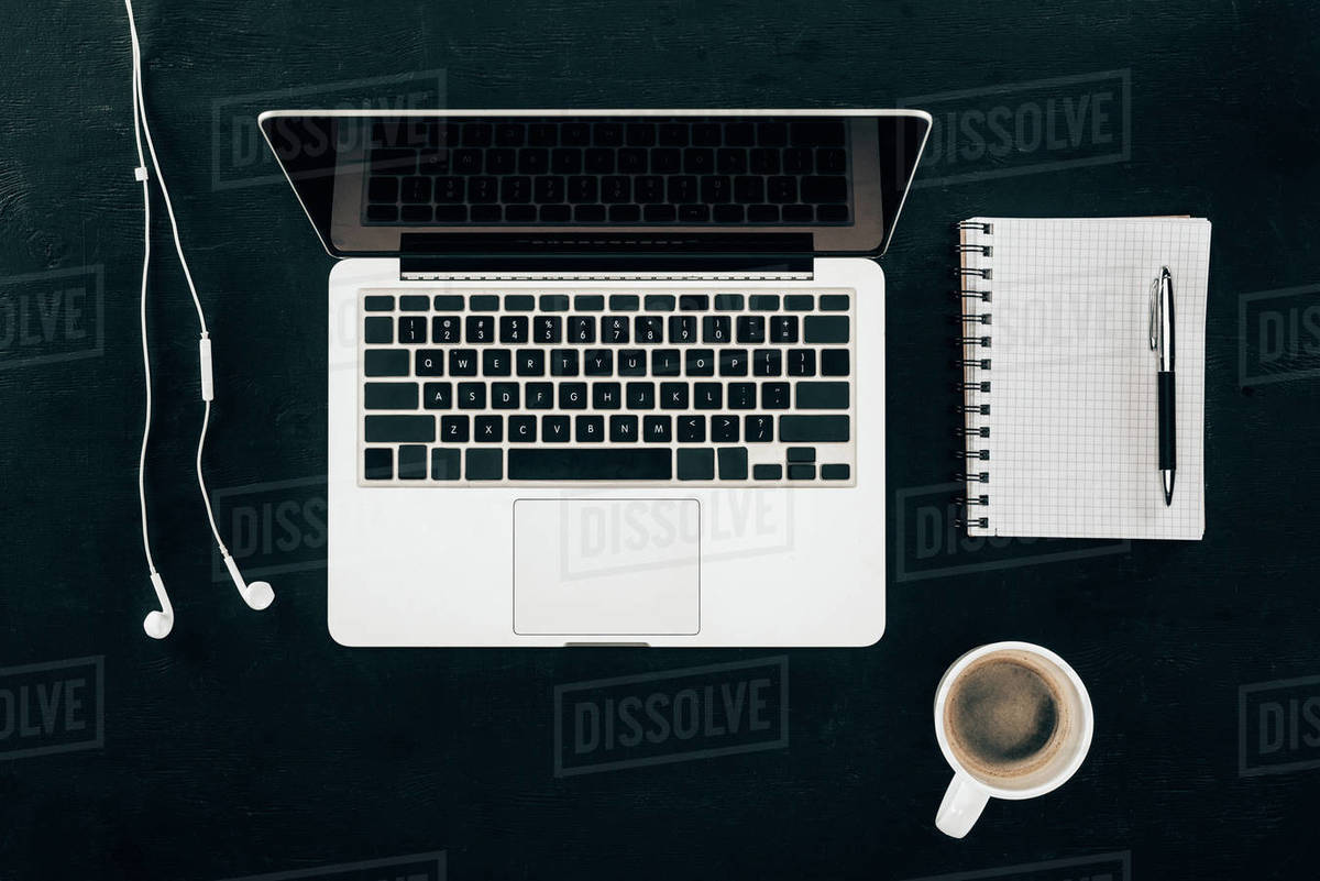 top view of workplace with laptop and cup of coffee isolated on black ...