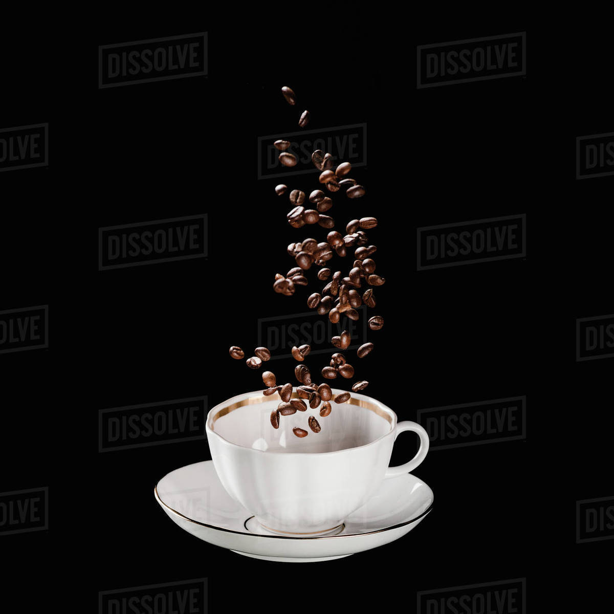 Coffee beans falling into cup isolated on black Stock Photo Dissolve