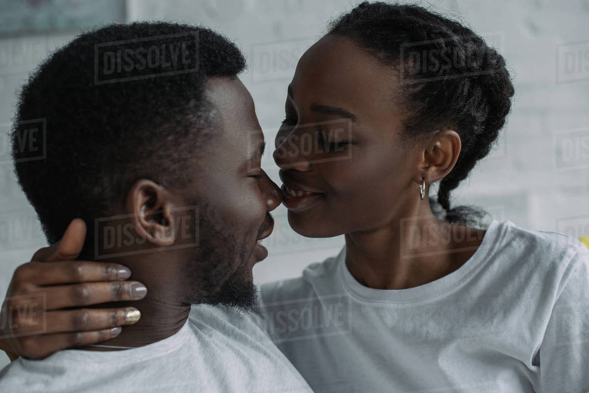 Beautiful happy young african american couple able to kiss at home ...