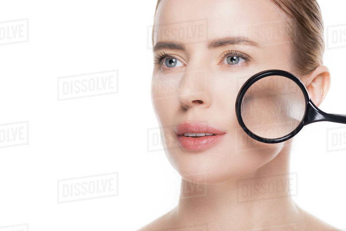 Magnifier on face of woman with clean skin isolated on white Stock Photo Dissolve
