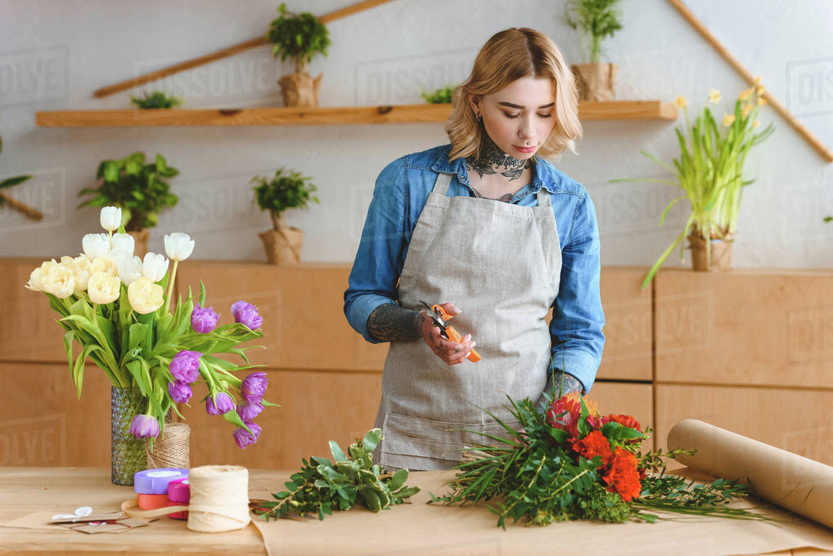 beautiful young woman arranging flowers in flower shop Stock Photo