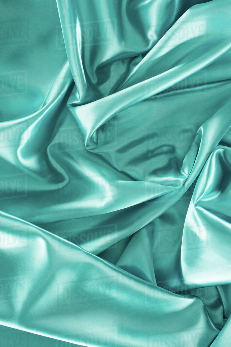 Turquoise crumpled shiny silk fabric background - Stock Photo - Dissolve