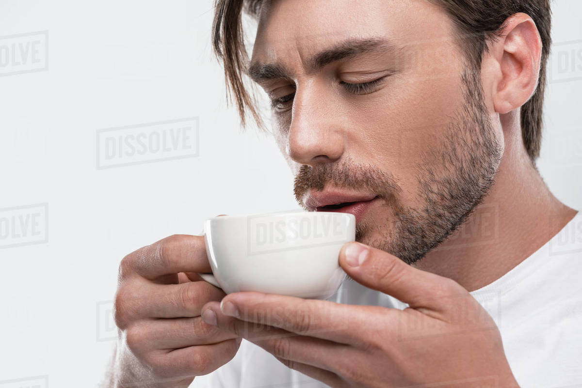 Handsome man with closed eyes drinking aromatic coffee, isolated on