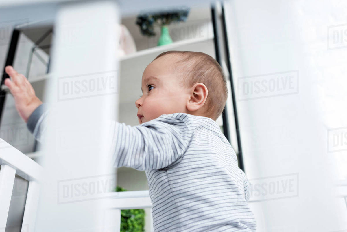 Bottom view of adorable little child in baby cot Stock Photo Dissolve