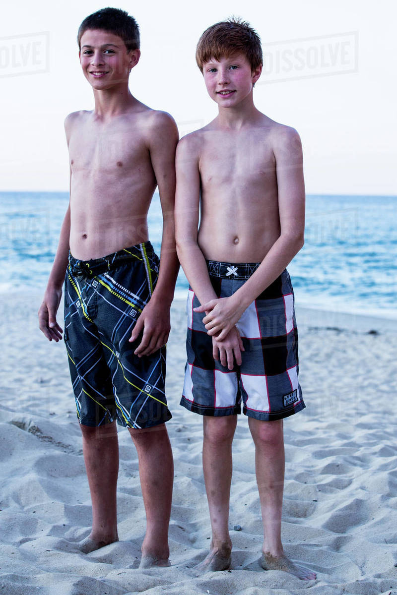 Portrait of two boys standing on beach - Stock Photo - Dissolve
