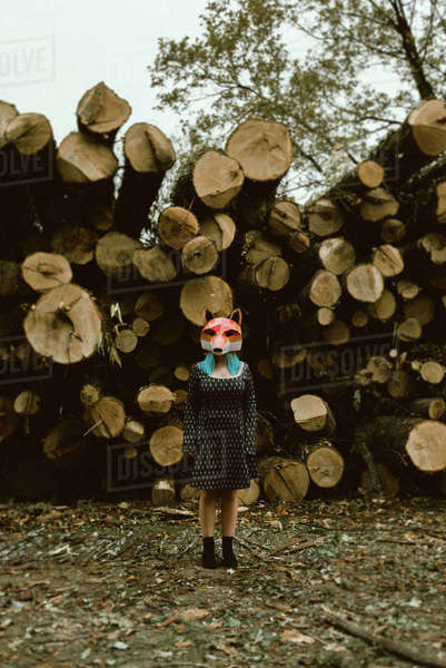 Anonymous female in paper fox mask covering full head looking away and ...