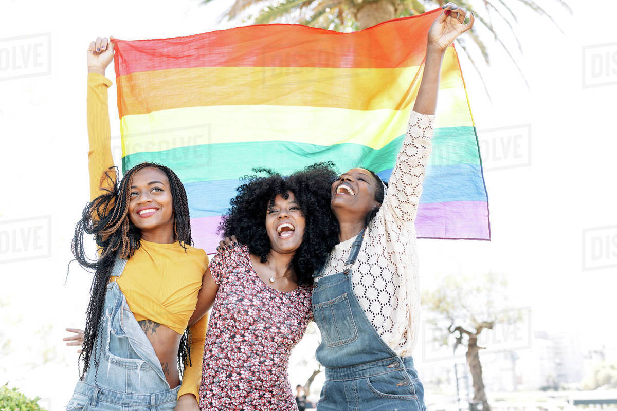 Low angle of delighted African American females in love hugging on ...