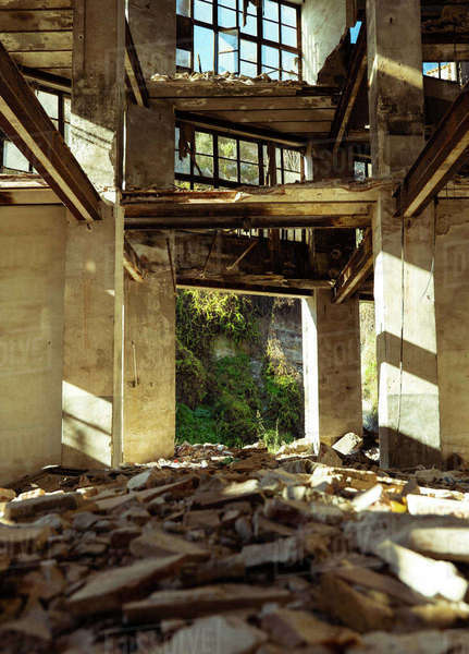Low angle inside of aged abandoned disrupted city building with trash ...