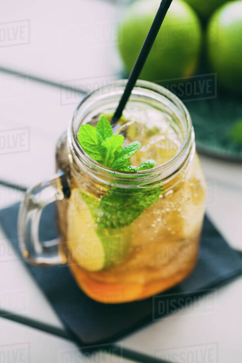 Mojito cocktail prepared with lime, mint, rum, soda and ice in mason