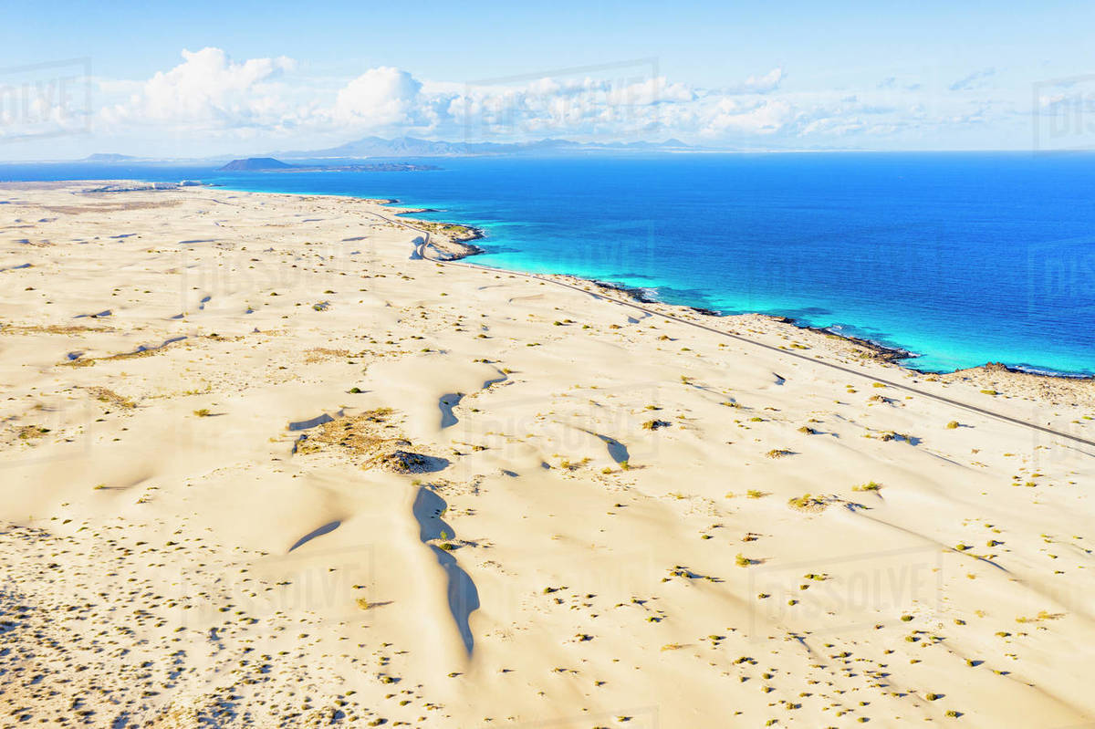 White sand dunes meeting the blue Atlantic Ocean, aerial view, Corralejo Nature Park White sand dunes meeting the blue Atlantic Ocean, aerial view, Corralejo Nature Park