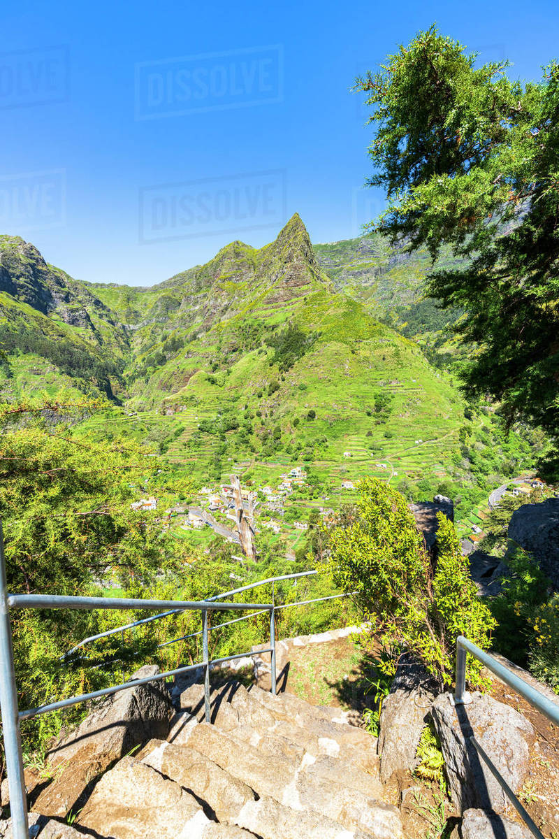 Steep steps on mountain path to the green alpine valley and village of ...