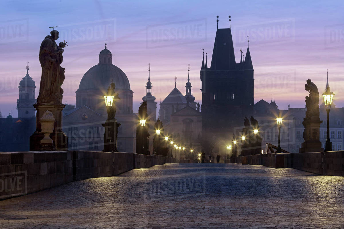 Street lanterns and old statues frame the historical buildings on Charles Bridge at dawn, UNESCO World Heritage Site, Prague, Czech Republic, Europe Royalty-free stock photo