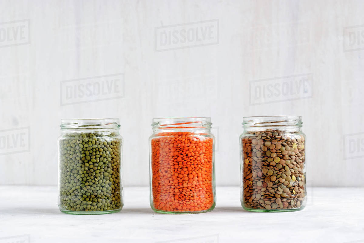 Dried Mung beans, and green and red lentils in glass storage jars
