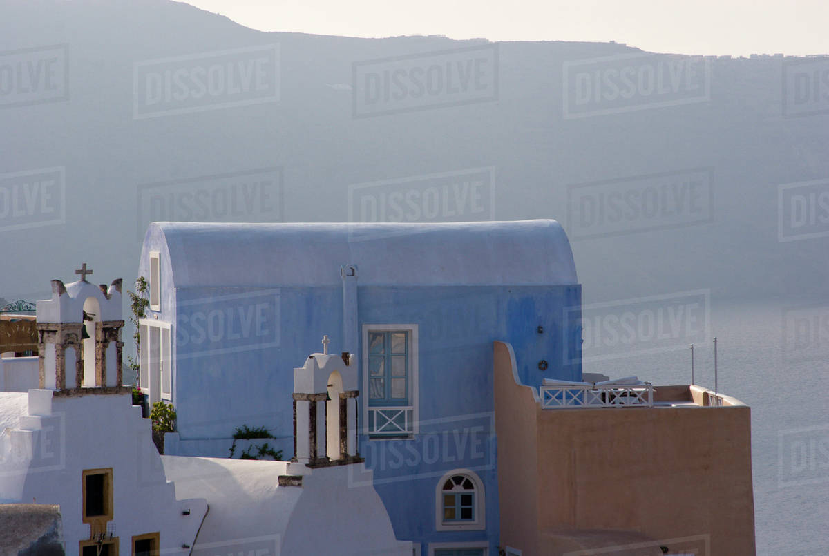 Greece, Santorini, Thira, Oia. Villa and patio with cliffs in distance