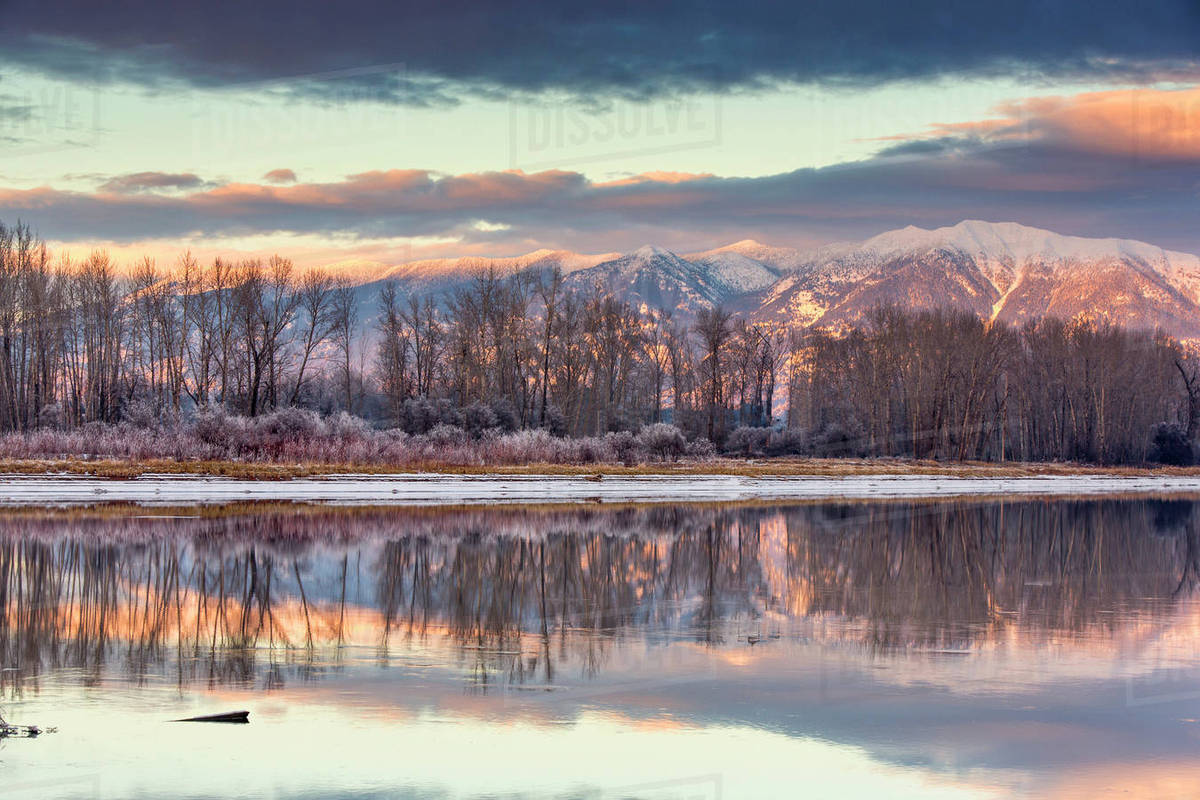 Swan Mountains reflect into the Flathead River at sunset near Kalispell
