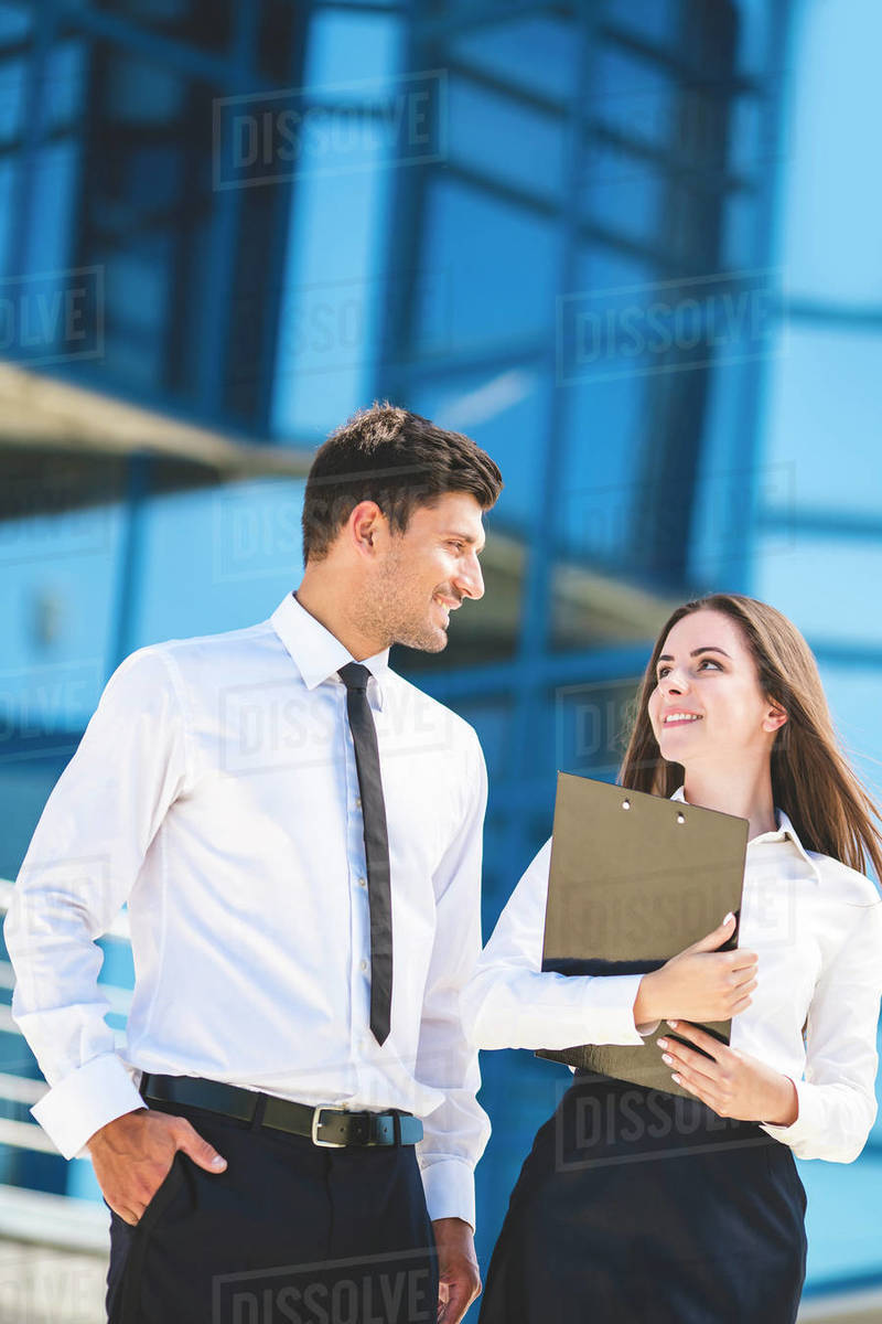 The happy man and woman stand on the background of the office center ...