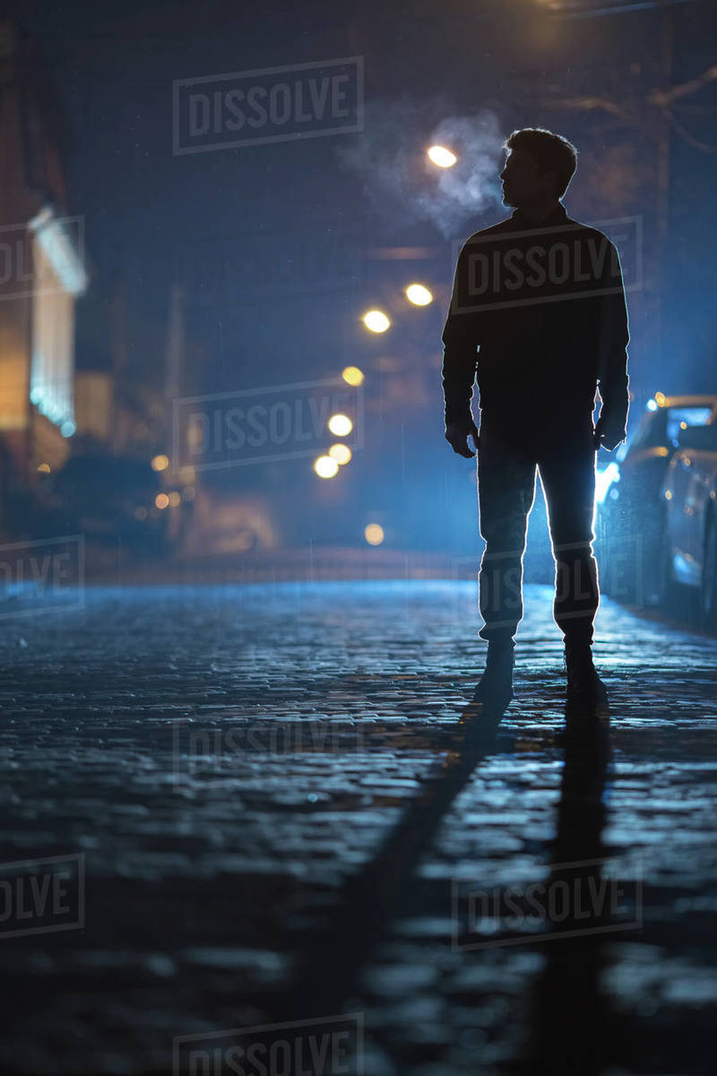 The man stand on the rain Evening night Telephoto lens