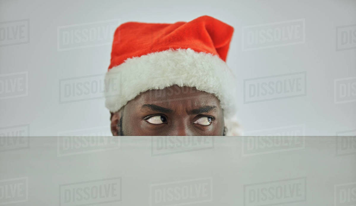 The african man in the santa hat watching from the table Royalty-free stock photo