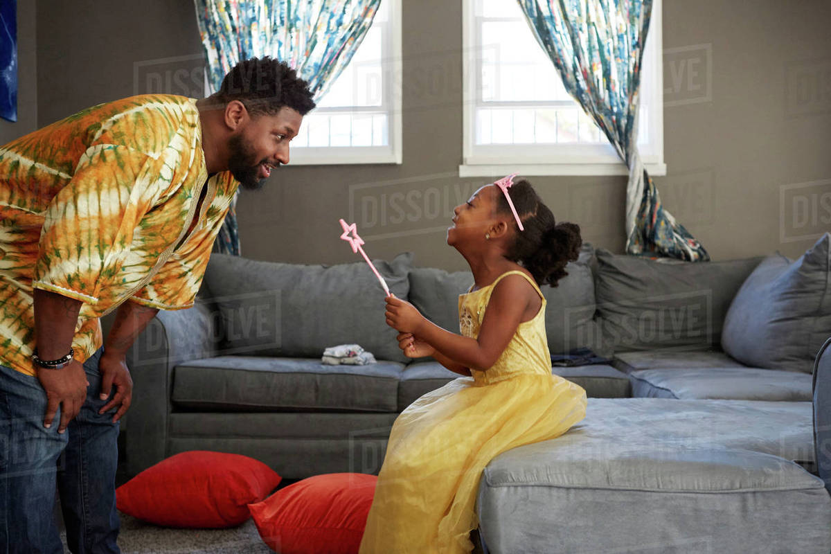 Man playing with daughter in fairy costume in living room Royalty-free stock photo