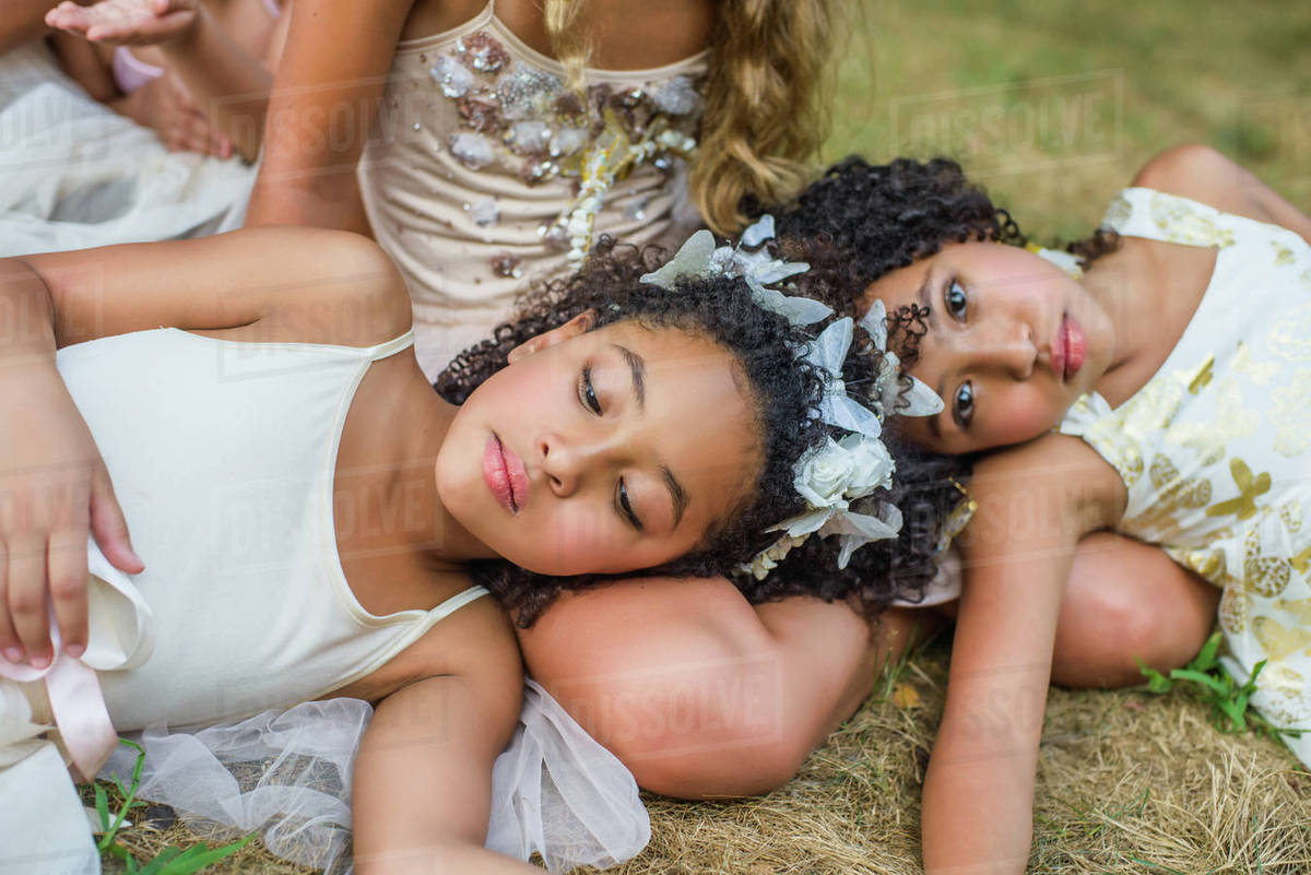 Group of young girls, dressed as fairies, lying on grass Royalty-free stock photo