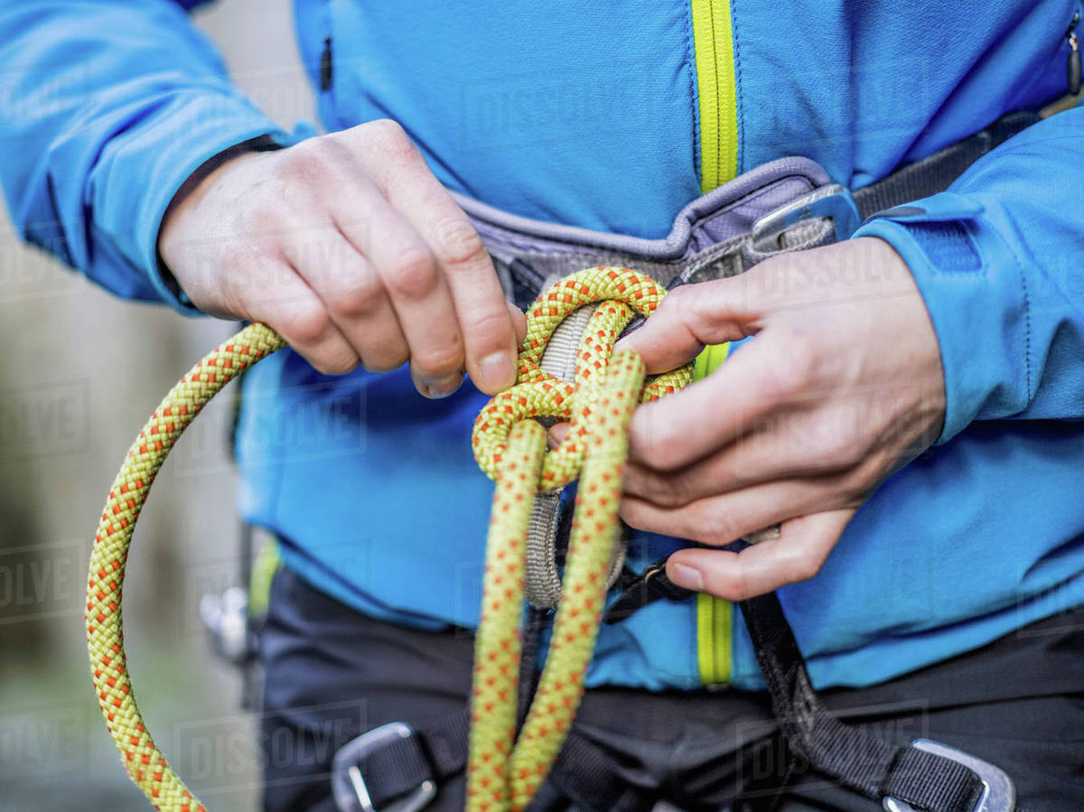 Rock climber tying rope Stock Photo Dissolve