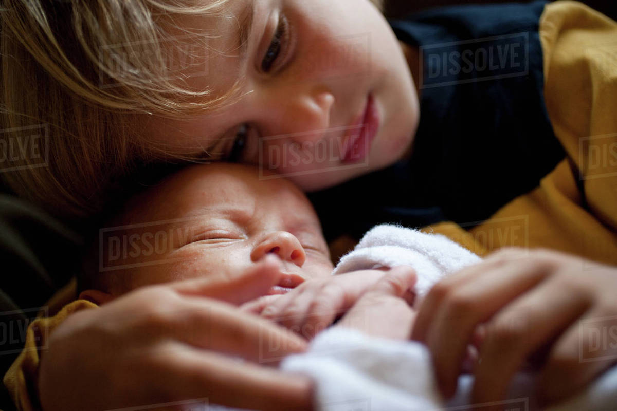 Young boy holding baby brother Stock Photo Dissolve