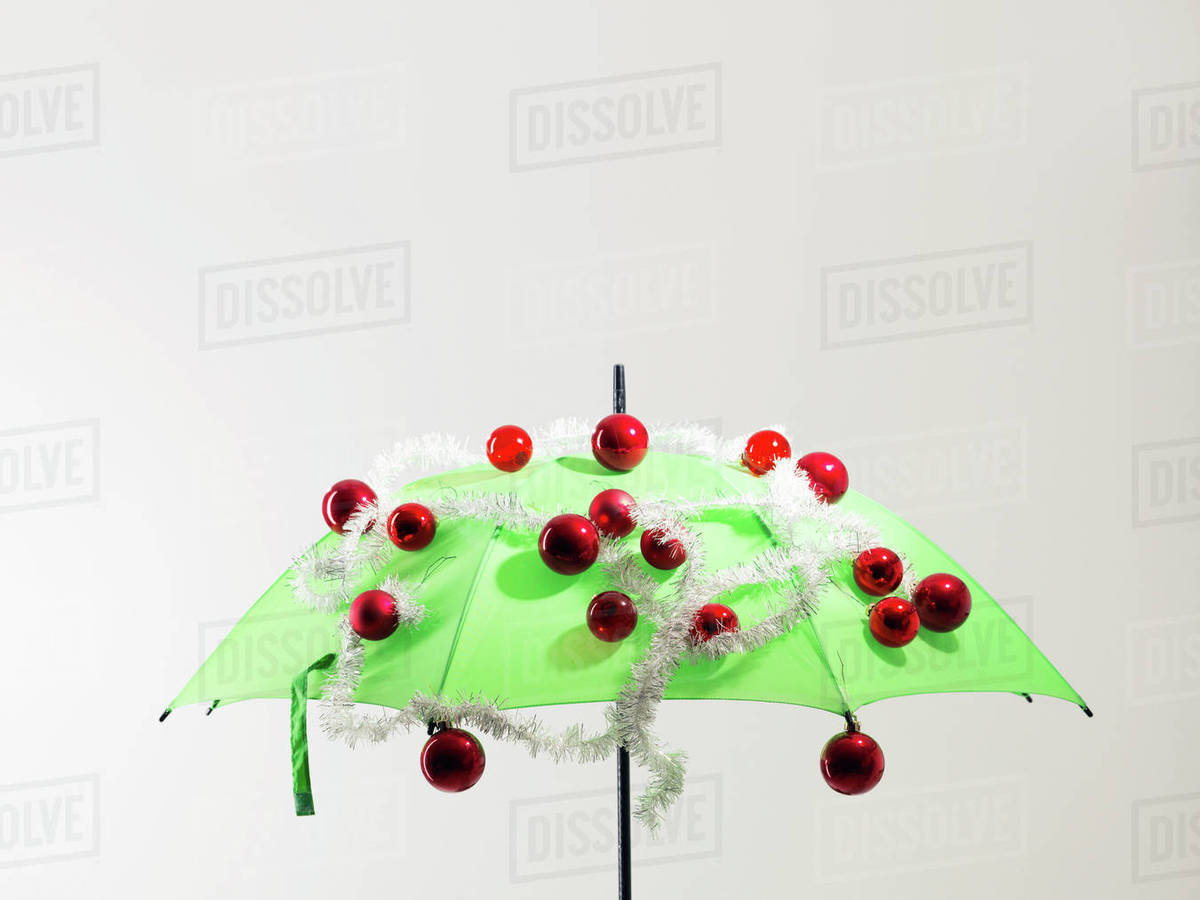 Green umbrella with Christmas decorations against white background Royalty-free stock photo