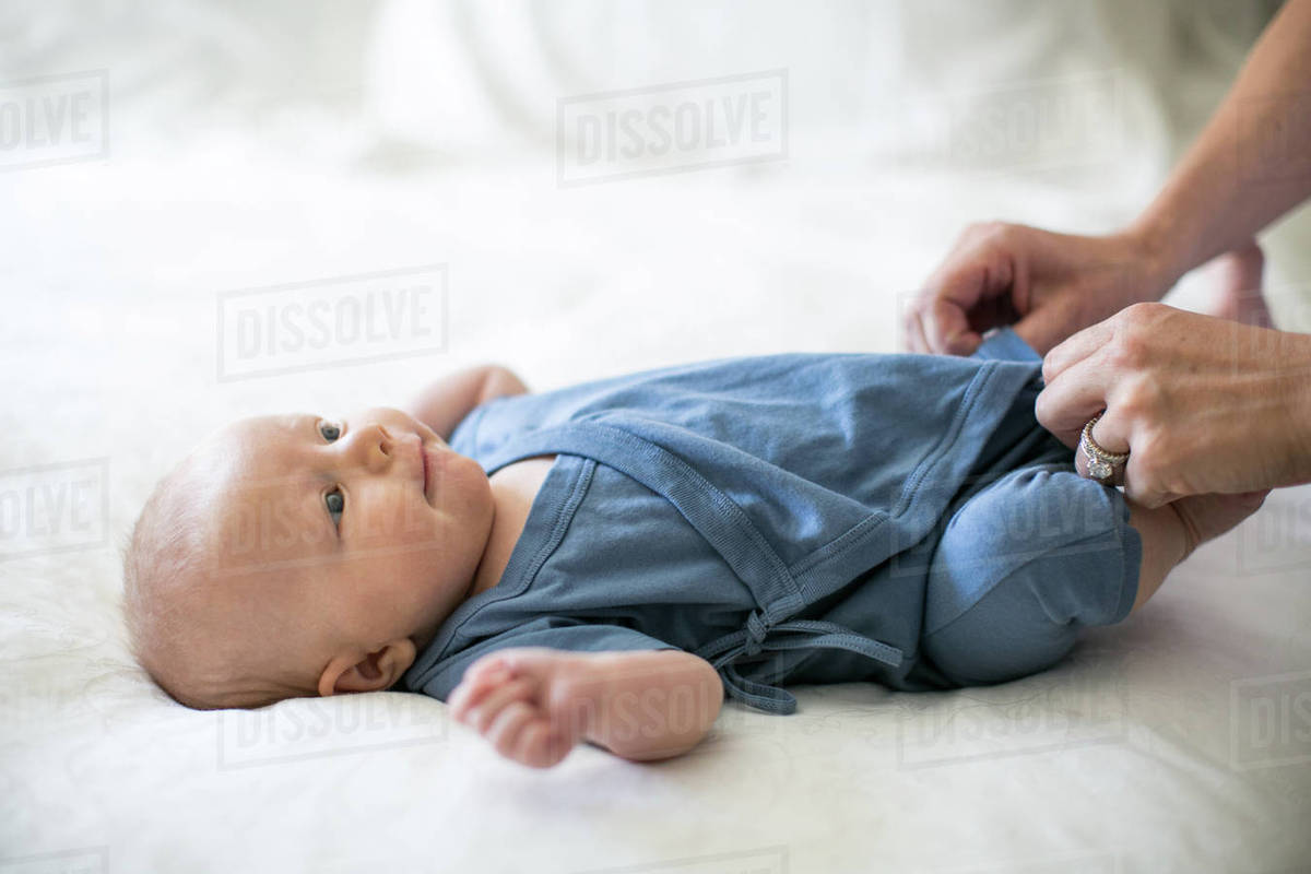Mother dressing baby boy, closeup Stock Photo Dissolve