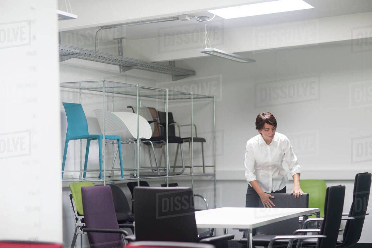 Young Female S Manager Organising Chairs In Office Furniture Stock Photo