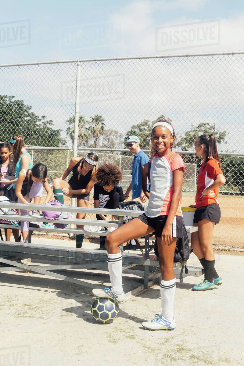 Portrait of schoolgirl soccer player at team practice on school sports