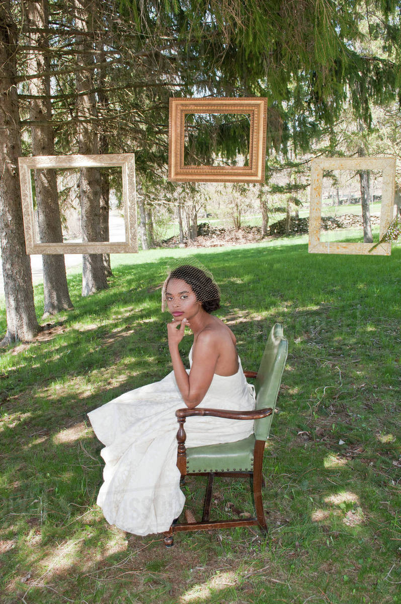 Portrait Of Bride Wearing Wedding Dress Sitting In Chair Outdoors Portrait Of Bride Wearing Wedding Dress Sitting In Chair Outdoors