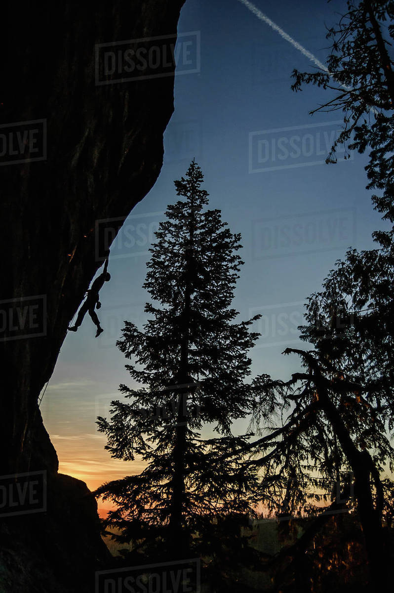 Silhouette of rock climber rock climbing at sunset, Flagstone, Eugene