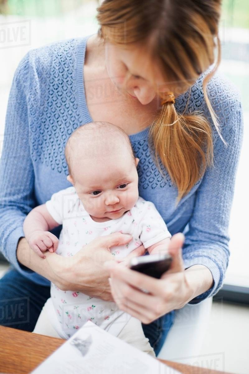 Mother with newborn baby and cell phone Royaltyfree Stock Photo