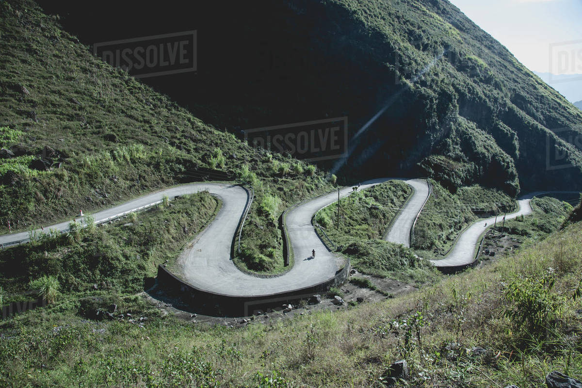 Winding road through mountains, motorcycles in distance, Vietnam