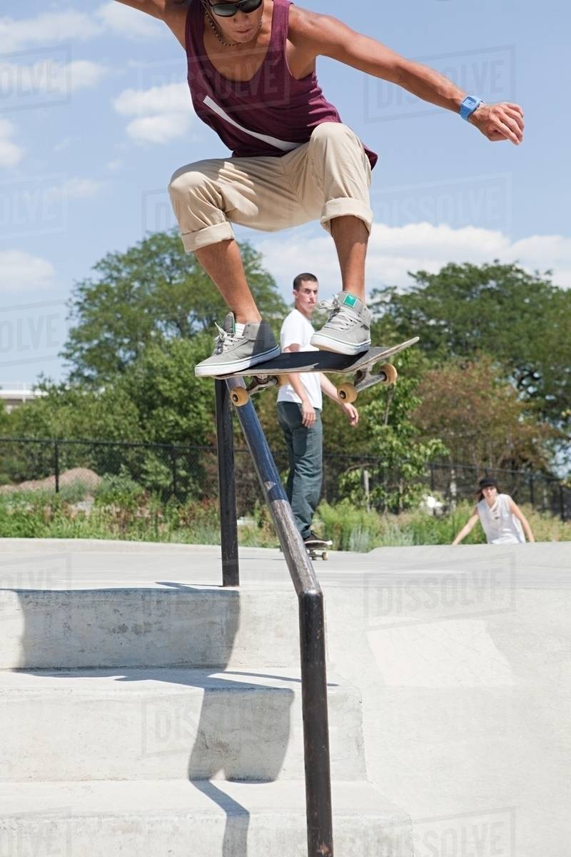 Skateboarder jumping over railing Stock Photo Dissolve