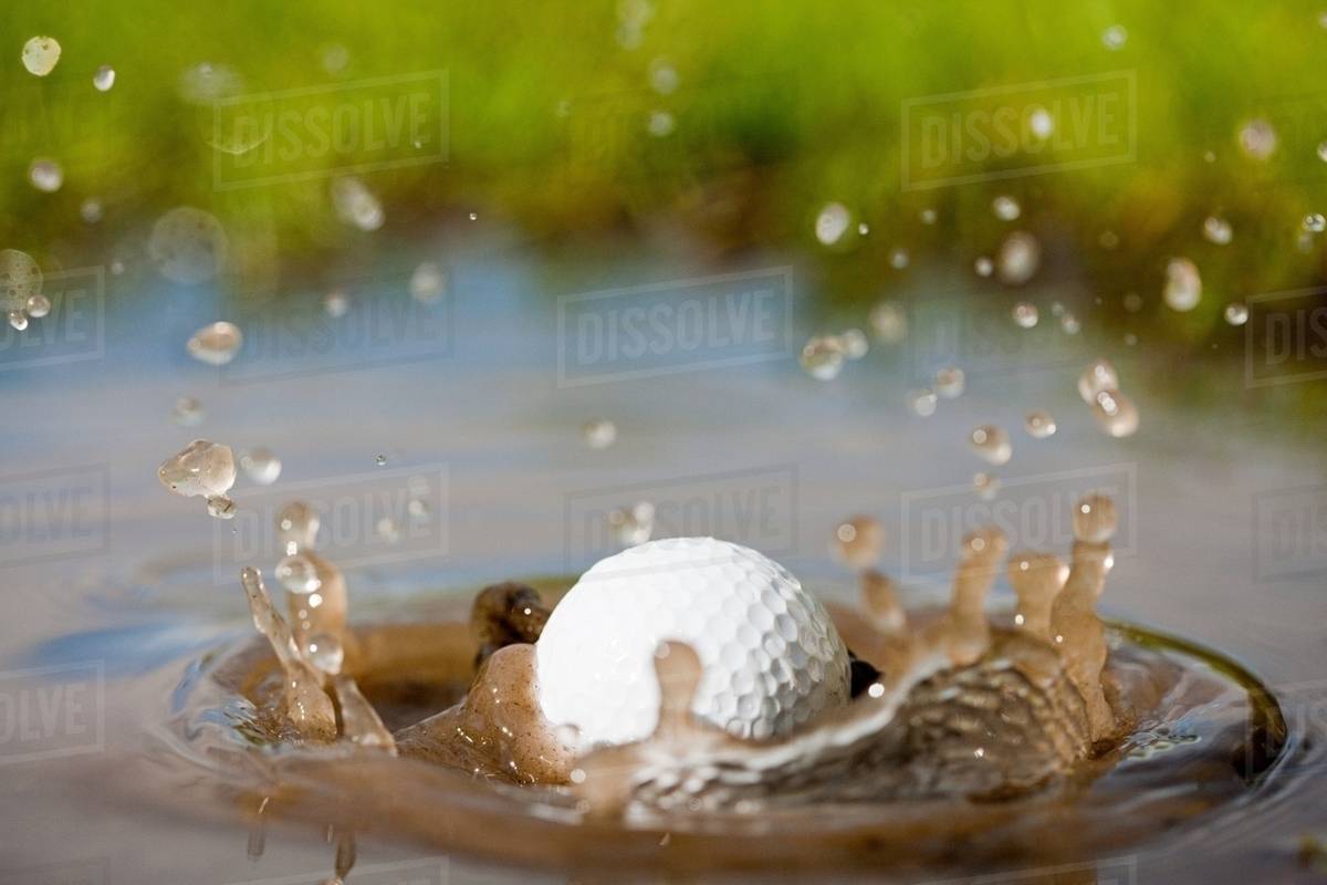 Golf ball splashing into water Stock Photo Dissolve